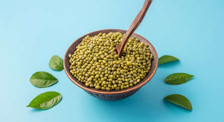 Bowl of green Asian beans and leaves on a blue background. Concept of healthy natural food.の写真素材