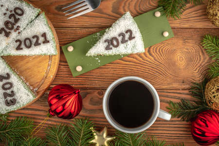 White festive cake decorated with numbers denoting the years. On the plate is a piece with the number 2022. Concept of the New Year. Top view.の写真素材