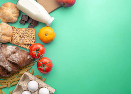 Vegetables, fruits, eggs, groceries on a green background top view. Set of fresh products in an online shop with home delivery and a healthy variety of food.の写真素材
