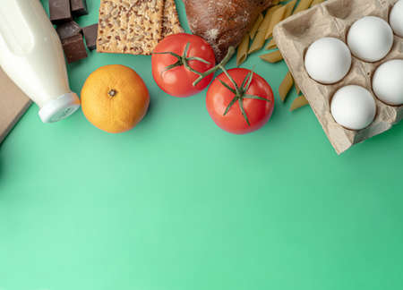 A set of fresh products for a healthy diet on the green background. Assortment for food delivery....