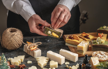 Woman is wrapping a beautiful natural soap. Concept of handmade organic gifts, useful hobby, festive atmosphere.の写真素材