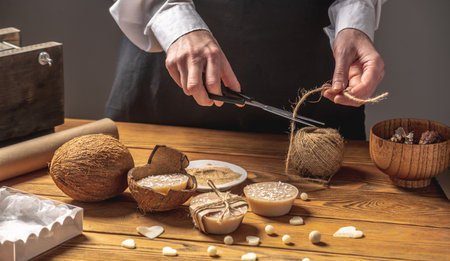 Woman is packing handmade natural coconut soap. Concept of making organic soap and cosmetics, a pleasant hobby, eco friendly care products.の写真素材