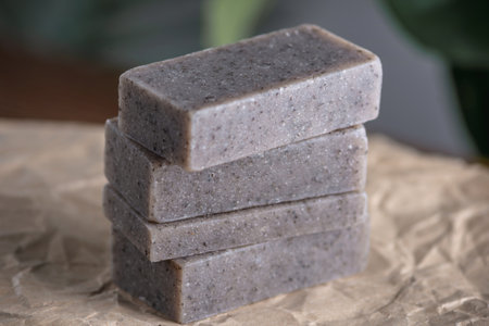 Pieces of handmade natural soap are stacked on a table covered with craft paper. Concept of making...