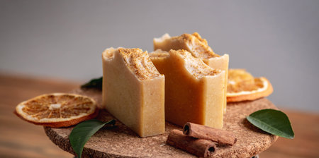Pieces of natural orange soap on the wooden background. Concept of making and using organic eco soaps and cosmetics.の写真素材