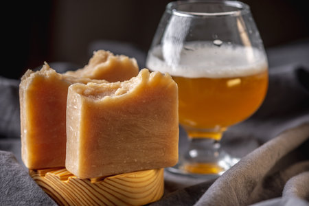 Pieces of natural soap on beer on a wooden soap dish and the dark background. Concept of an original unusual handmade gift for men.の写真素材