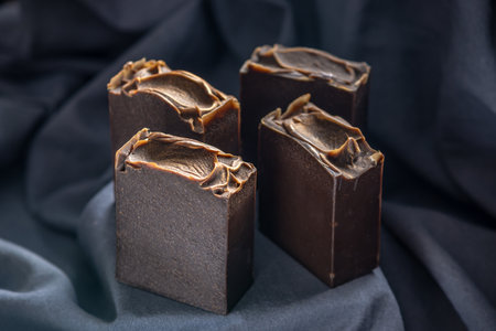 Pieces of craft natural tarry soap on a black fabric background