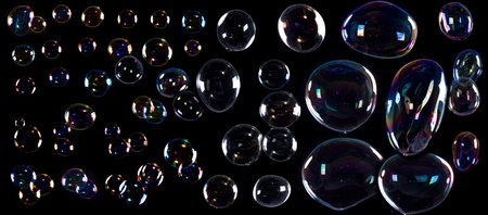 girl is doing soap bubble show on the black background