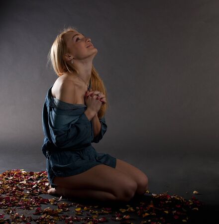 thoughtful young woman is sitting on the floorの写真素材