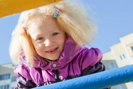Little girl with blond hair is smiling and playingの写真素材
