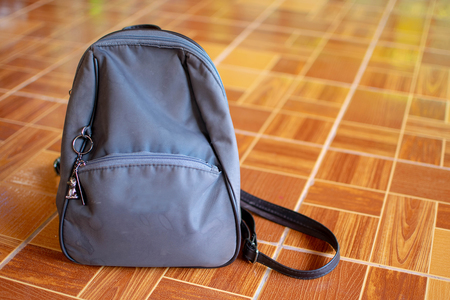 Gray backpack lying on an orange floor.の写真素材