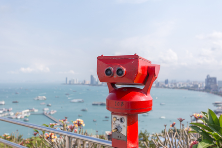 Red binocular with sea and city in backgroundの写真素材