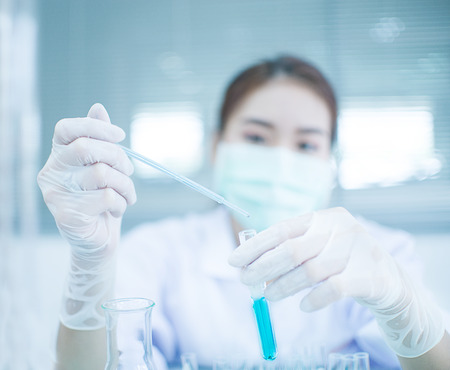 Young Asian scientist with test tube making research in clinical laboratory.Science, chemistry, technology, biology and people conceptの写真素材