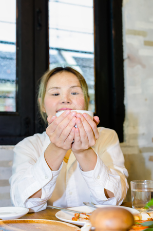 Young women drinking hot coffeeの写真素材