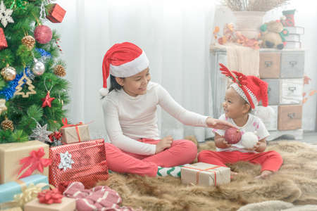 Merry Christmas and Happy Holidays! Cheerful 2 little girls playing and have fun together.の写真素材