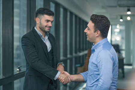 Two businessman standing and discuss a work or project strategy. Colleague talking and asking for the work opinion.の写真素材