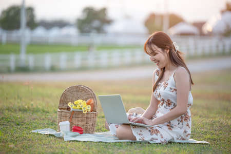 Excited infant daughter girl looking how your mother eat grape during picnic. Hungry woman funny posing with enjoying playing time while her daughter happy and smiling.の写真素材