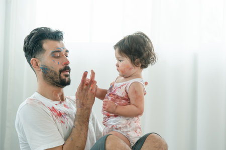 Young mix race father playing color painting with little baby cute girl. Dad takes care of baby...