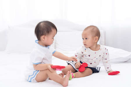 Little two Asian baby girls plaing together at home.の写真素材