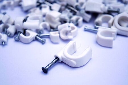 Plastic nail clips for wire on white background.