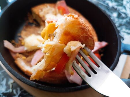 Pizza food, ham sausages, fried eggs, tomato sauce in a black pan.の写真素材