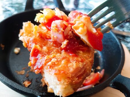 Pizza food, ham sausages, fried eggs, tomato sauce in a black pan.の写真素材