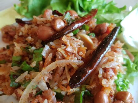 Fried Nham Salad, sour pork, Thai hot spicy food with chillis and green lettuce vegetables in a dish.の写真素材