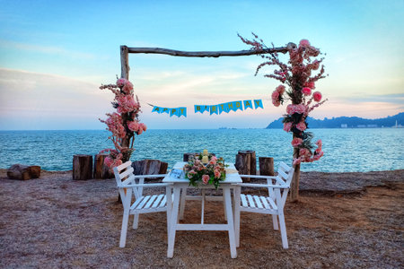 Romantic beach with white picnic seats and flowerの写真素材