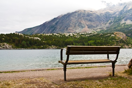 an empty bench at a mountain lakeの写真素材