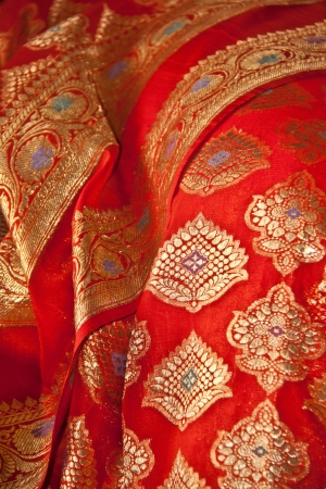 an Indian Sari with orange fabric and Gold threadの写真素材