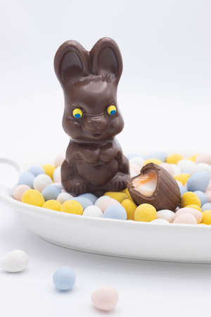 Chocolate bunny with cadbury creme egg on top of candy eggsの写真素材