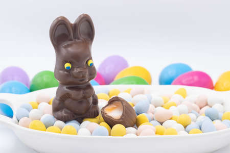 Chocolate bunny with cadbury eggs and plastic easter eggsの写真素材