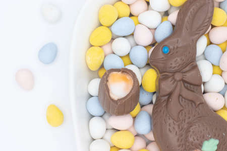 Chocolate bunny with cadbury creme egg on top of candy eggsの写真素材
