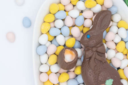 Chocolate bunny with cadbury creme egg on top of candy eggsの写真素材