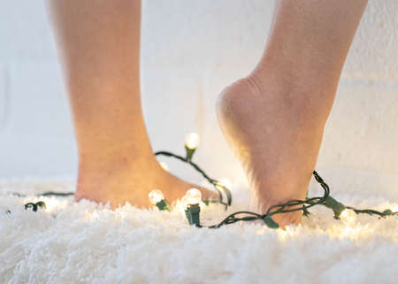 bare feet on a fuzzy blanket with christmas lightsの写真素材