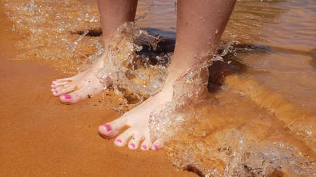 Bare feet with a pedicure on a beach vacationの写真素材