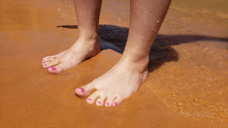 Bare feet with a pedicure on a beach vacationの写真素材