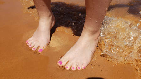 Bare feet with a pedicure on a beach vacationの写真素材