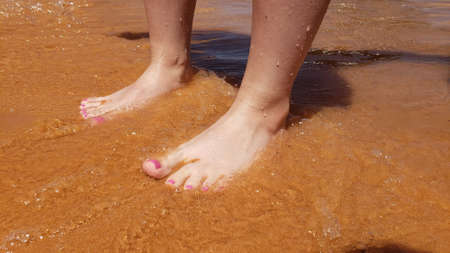 Bare feet with a pedicure on a beach vacationの写真素材