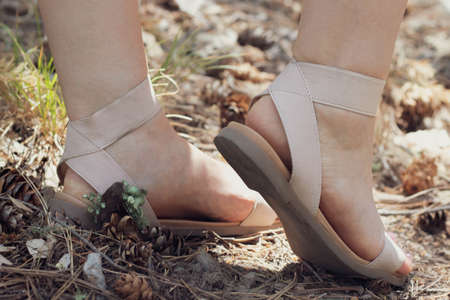 feet in tan shoes walking in natureの写真素材