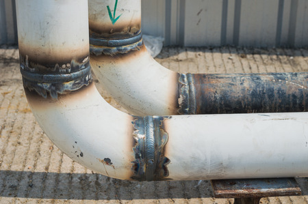 The close up weld on a steel pipes for a new heat line. The welded joint on a steel pipes,high...