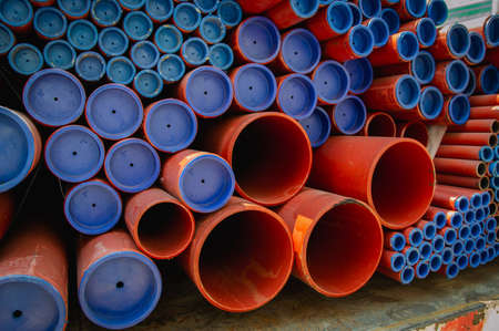 Red steel pipes for fire fighting system and extinguishing water lines in industrial building. Paint...