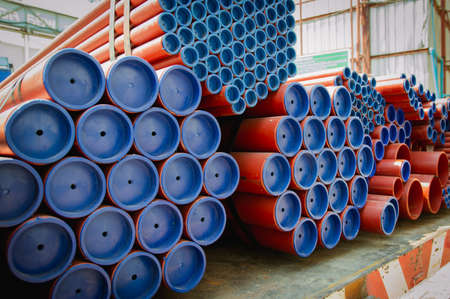 Red steel pipes for fire fighting system and extinguishing water lines in industrial building. Paint...