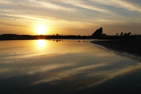 A golden sunset reflected in the river at Whatipu Beach, Waitakere Ranges, Auckland, New Zealand.の写真素材