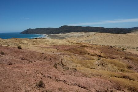 The moon-like colored clay hills of the New Zealands Cape Reinga in Northland, and Te Werahi Beachの写真素材