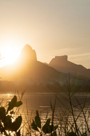 Golden sun dips below the horizon against Morro Dois Irmaos Two Brothers Mountain and Pedra da...