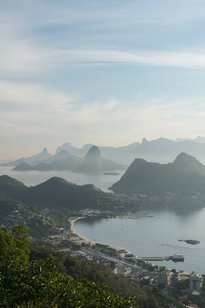 Evening view from the Parque da Cidade City Park lookout in Niteroi, overlooking Guanabara Bay and the city of Rio de Janeiro. There is blue sky, and mountains such as Sugarloaf and Dois Irmaos.の写真素材