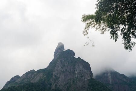 The steep forested rock mountains of the Serra dos Orgaos National Park,Teresopolis, Rio de Janeiro, Brazil, on a cloudy day. The dramatic peaks include Dedo de Deus - Finger of God and Escalavrado.の写真素材