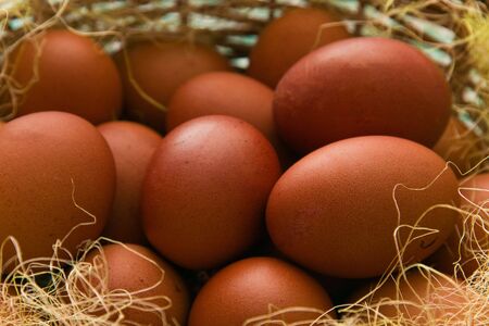 Red easter eggs gathered in a brown wicker basket.の写真素材