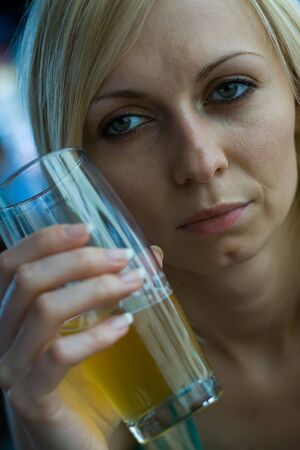 Young woman enjoying a beer at a barの写真素材