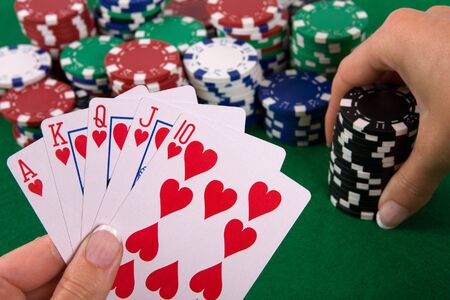 Cards with poker arrangement and female hand betting in the background.